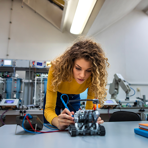 female student practicing on a robot