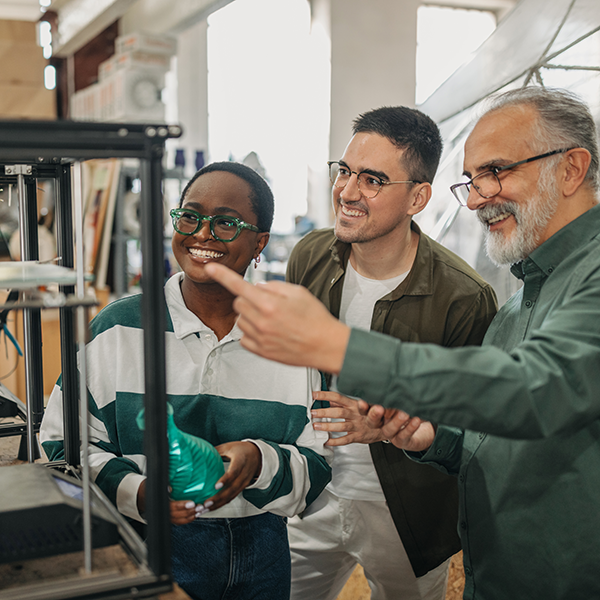 A professor talks to two students in the Collaboratorium.